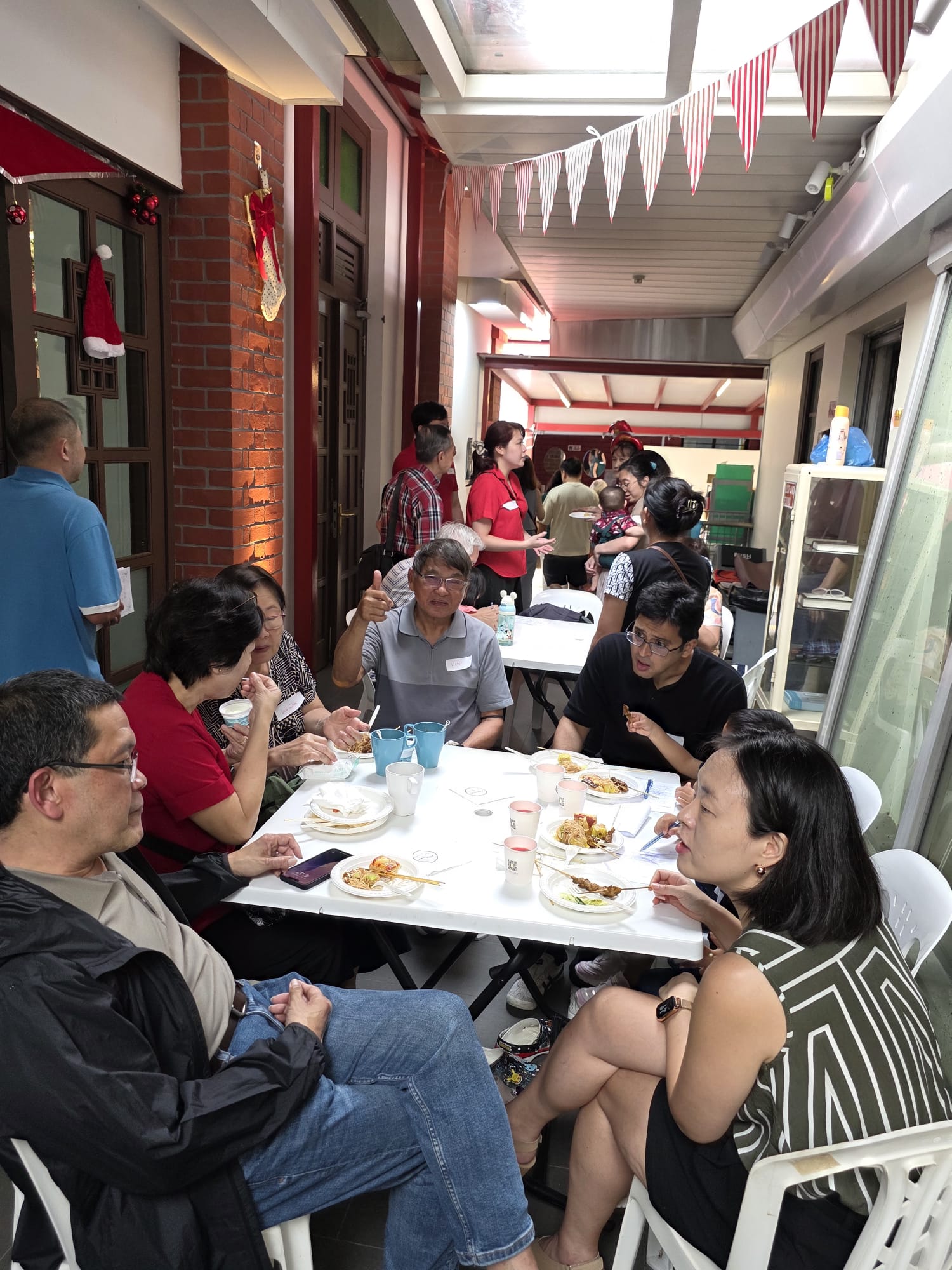 4 Chairman Khoo Teng Cheong (foreground) and Joanne Lee (in red) talk to guests at the party. jpg